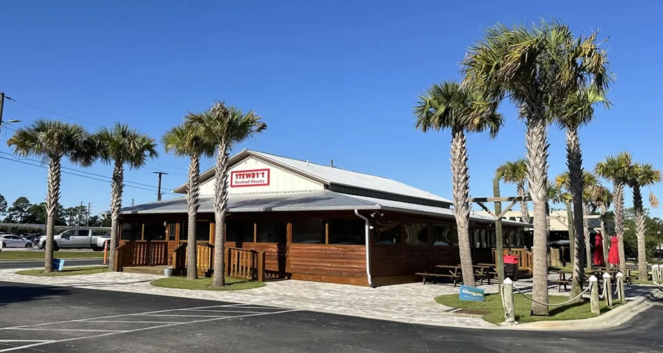 Palm trees surrounding a wooden restaurant building.