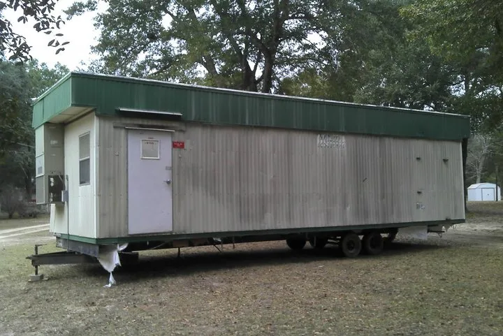 Mobile office trailer in a wooded area.