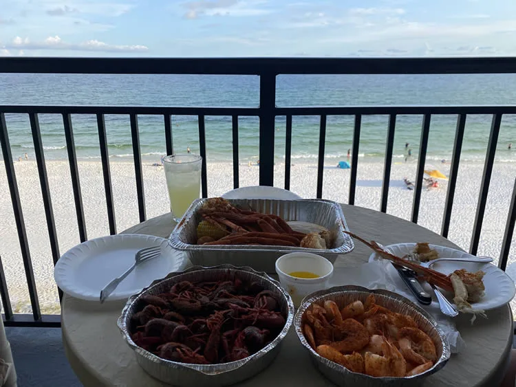Seafood meal on beachside balcony with ocean view.