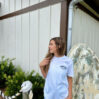 Woman in white t-shirt near rustic building