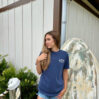 Woman in navy shirt by vintage surfboard.