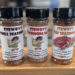Three bottles of Stewby's seasoning blends on shelf.