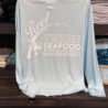 Blue seafood restaurant shirt on display shelf.