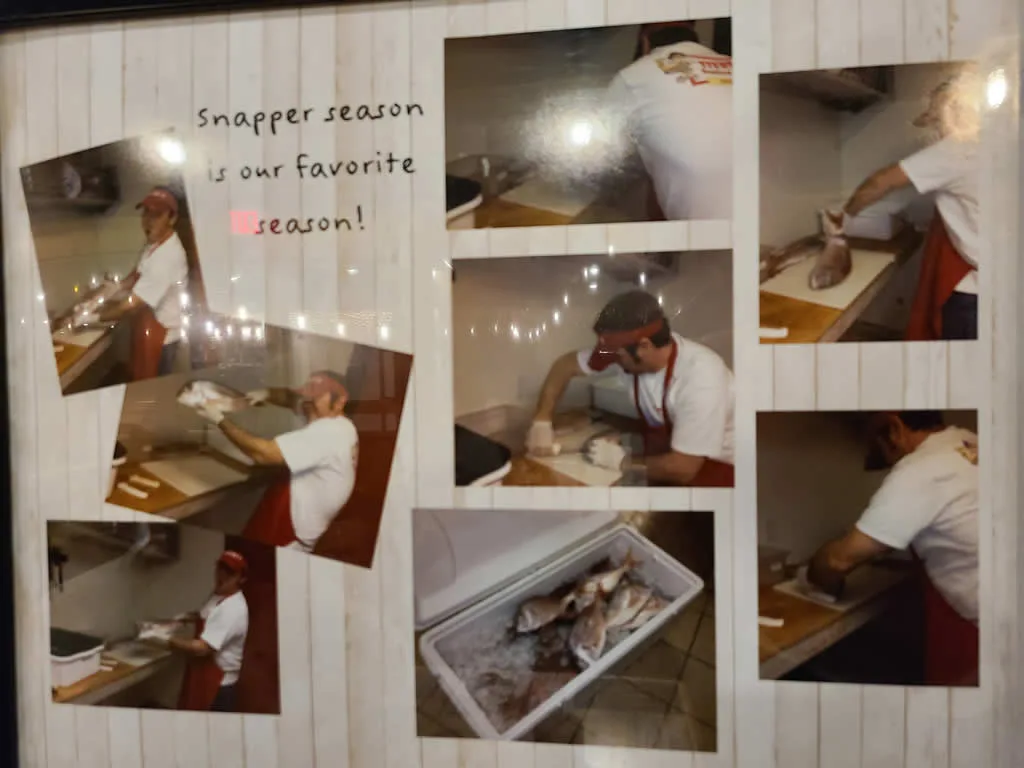 Person preparing snapper fish in kitchen.