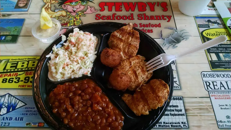 Plate of grilled chicken, coleslaw, beans at Stewby's.