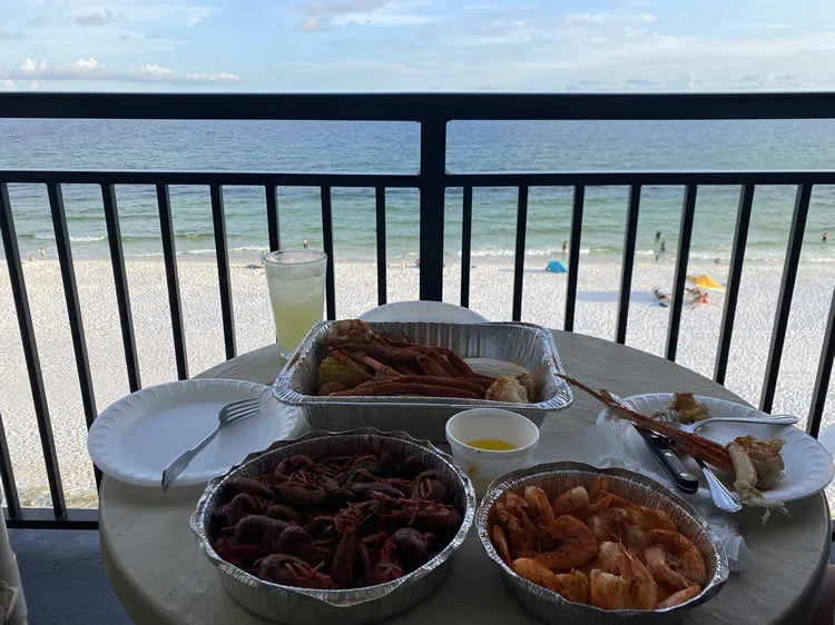 Seafood feast on table overlooking beach view.