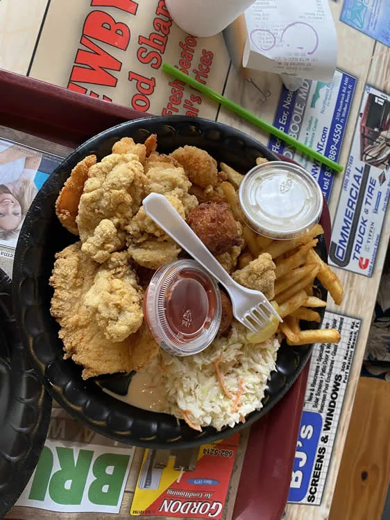 Fried seafood platter with fries and coleslaw.
