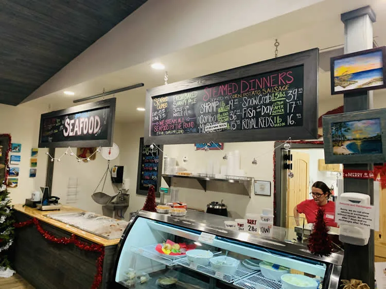 Seafood restaurant interior with menu boards and counter.