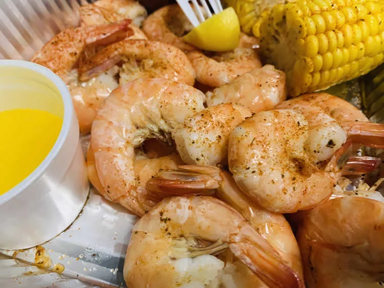 Boiled shrimp with corn and melted butter.