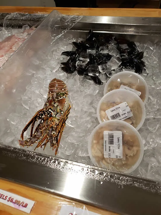 Fresh seafood display with lobster and shellfish on ice.