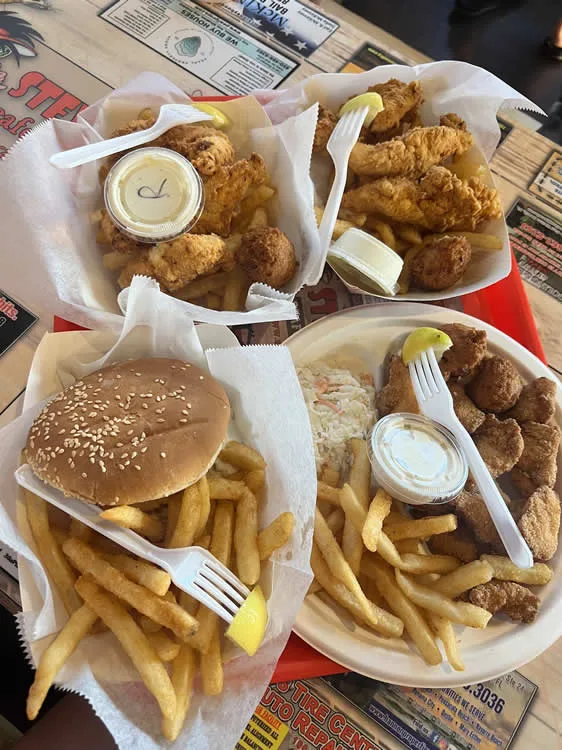 Fried chicken, fries, and burger meal on tray.