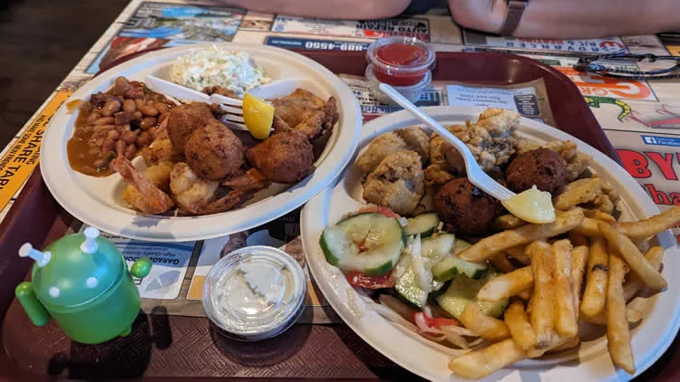 Seafood platter with fries, coleslaw, and beans.