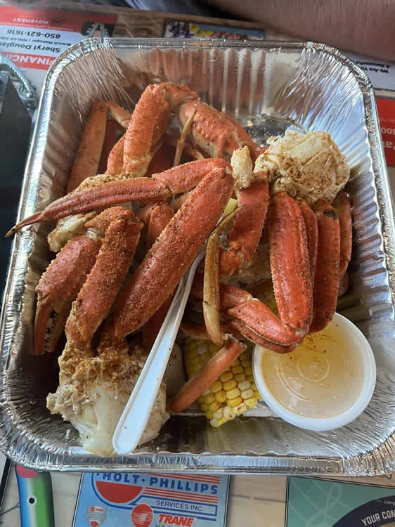 Crab legs with corn and butter sauce in tray.