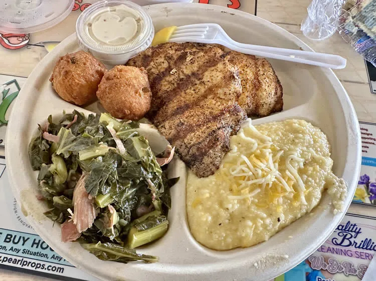 Southern comfort food plate with fish, grits, greens.