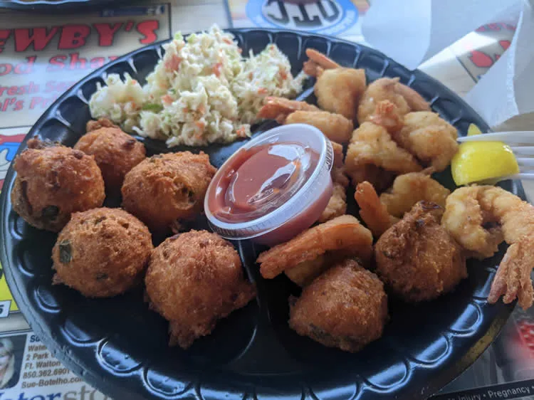 Fried shrimp and hushpuppies with coleslaw and sauce.
