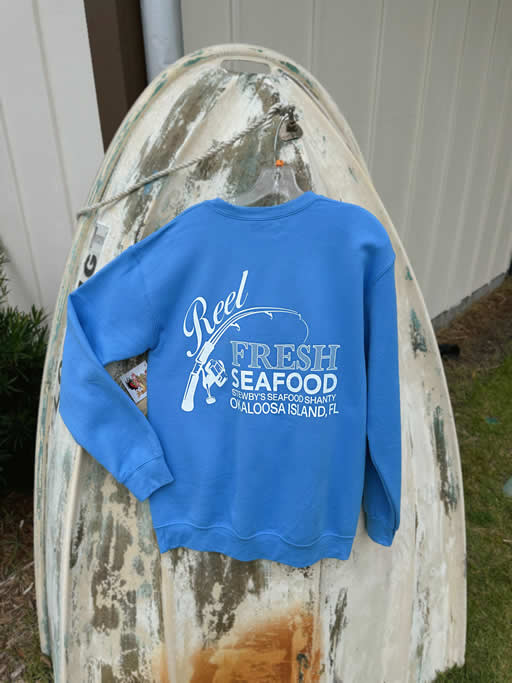 6D7B2508-52ED-4958-B80E-675EAC440F80 Blue sweatshirt with Reel Fresh Seafood logo on boat